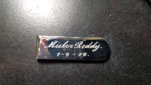 hand engraving name and date onto money clip- this message R140